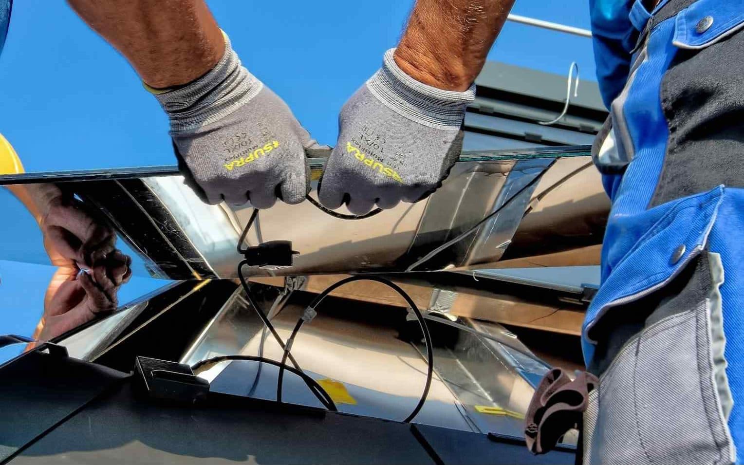 Technician in work gloves checking solar panel cable connectors